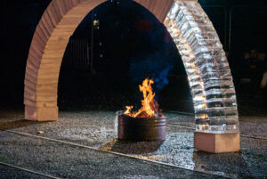 an arch made from concrete and ice with a fire underneath it